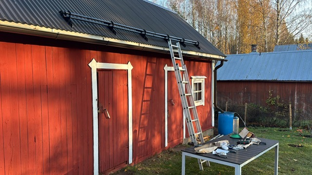 Vanhan talon pihavarasto, jonka katolle on asennettu lumiesteet.