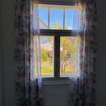 Makuuhuoneen verhot ja niihin sopiva tapetti vanhassa talossa.